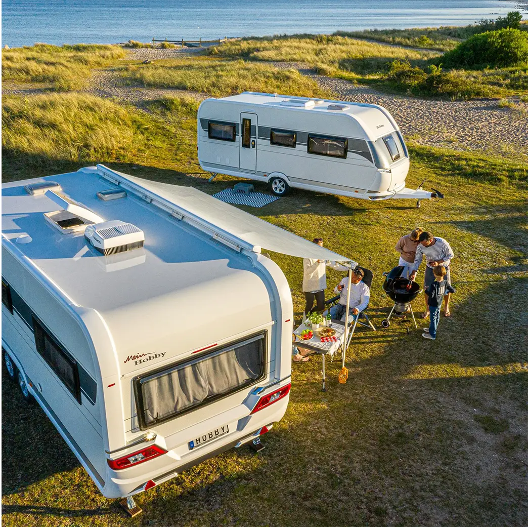 sfeerfoto caravans naast het water in kleur twee gezinnen 2024